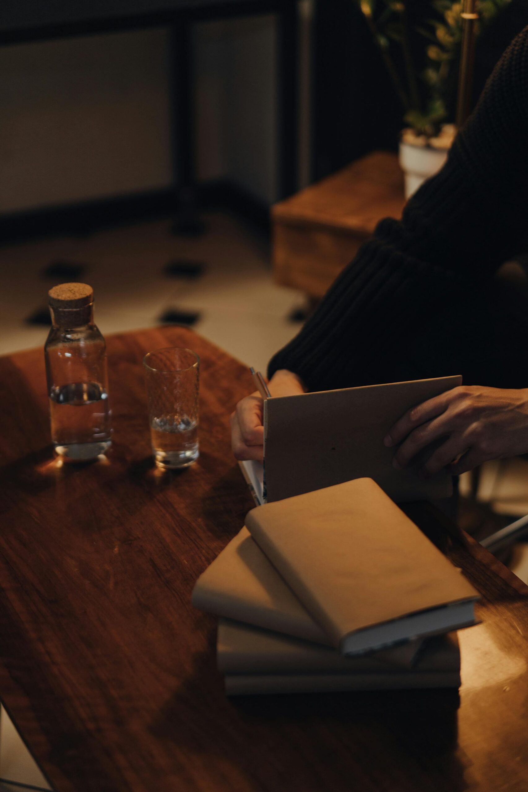pexels-photo-4865545-4865545 Warm indoor setting featuring a person signing books, perfect for cozy atmosphere themes.