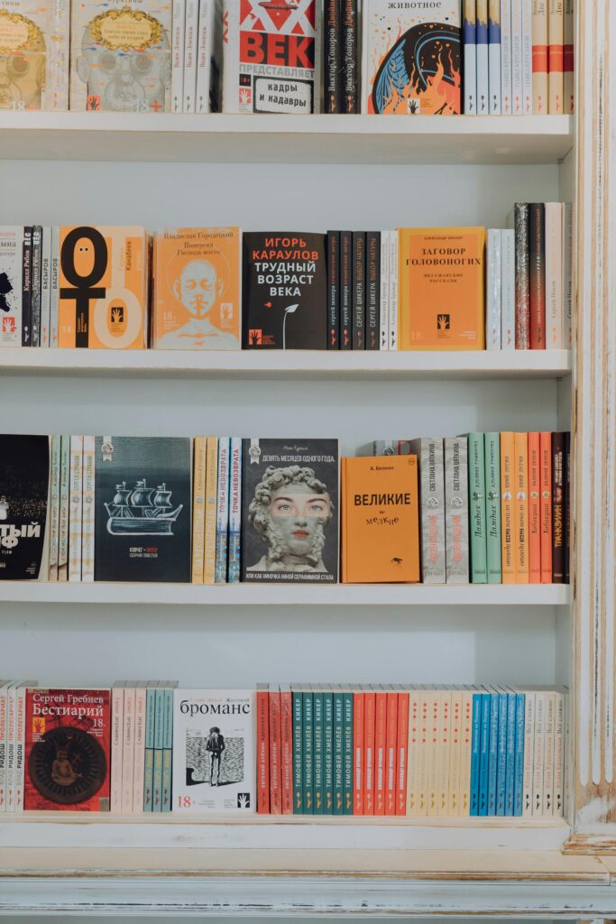 pexels-photo-4865718-4865718-1 A vibrant collection of books displayed on a decorative white bookshelf.