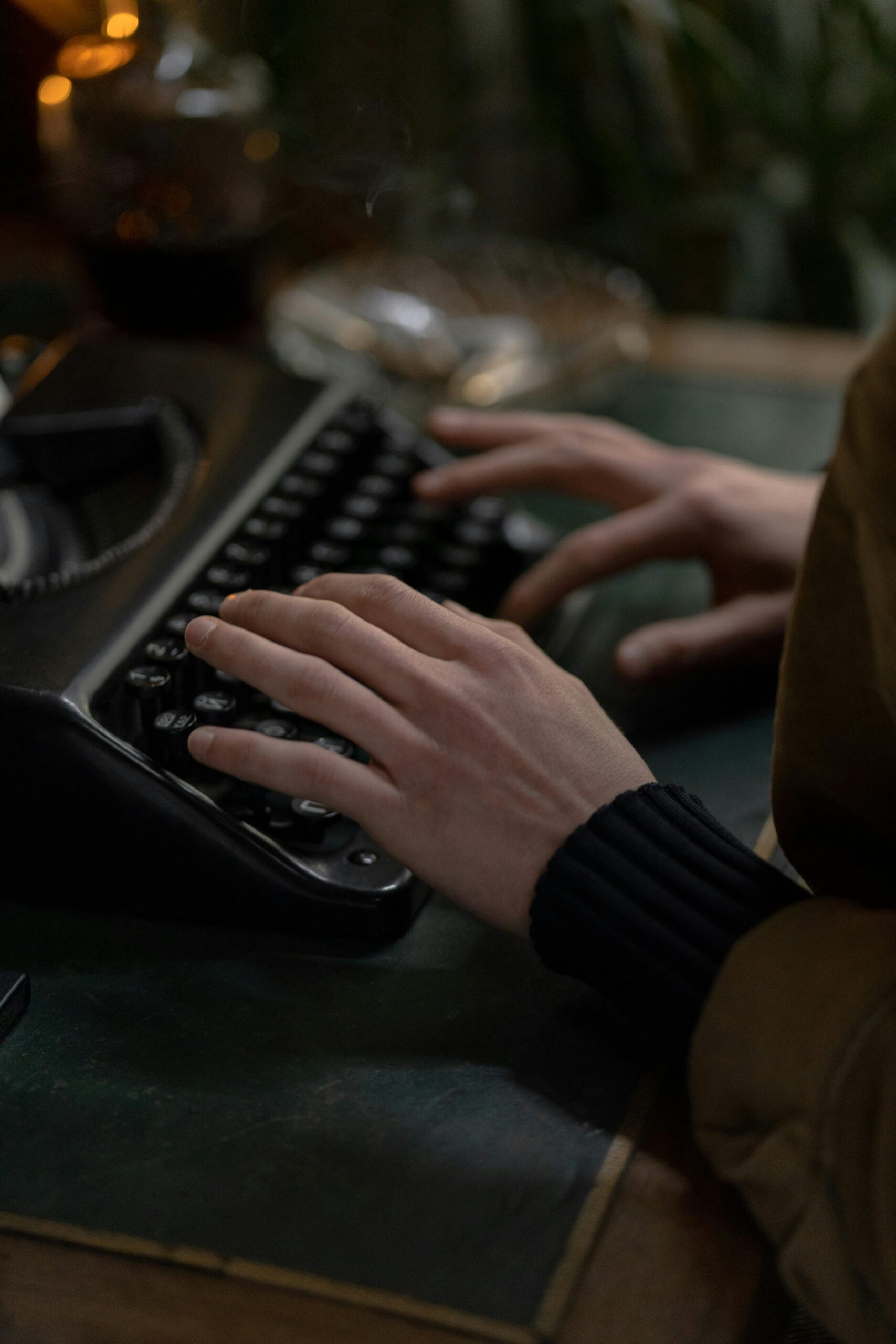 pexels-photo-6037575-6037575 Hands of an adult typing on a vintage typewriter, set indoors with classic tones.
