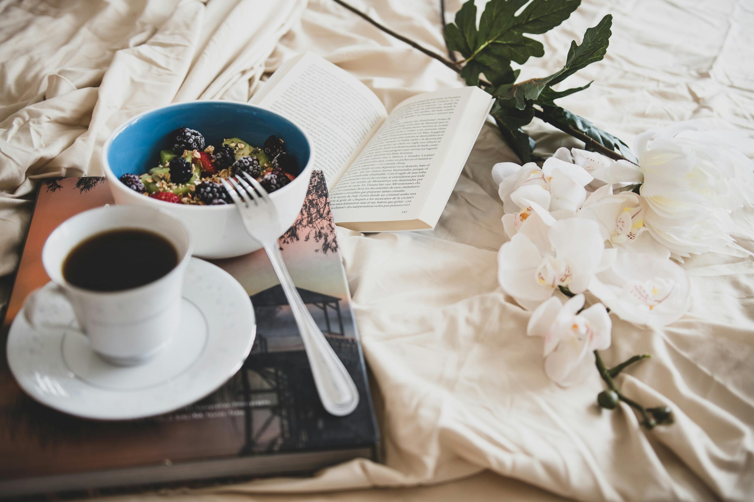 Relax with a book, a cup of coffee, and a fresh fruit bowl on a cozy morning.